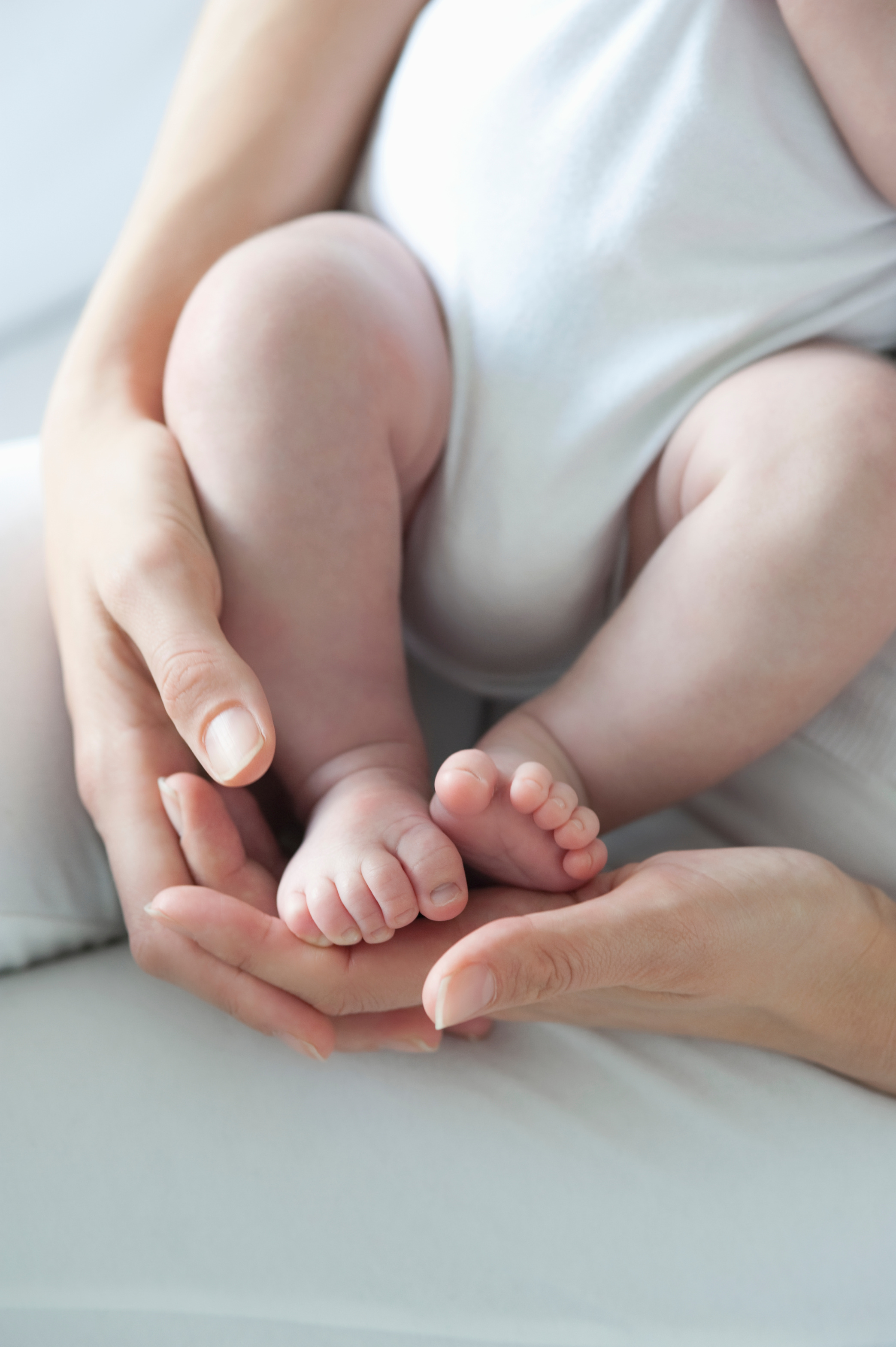 Mother holds baby boys feet